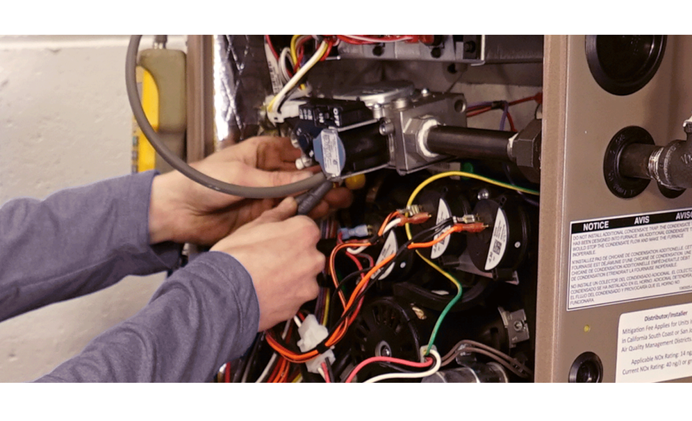A pair of hands fixing a a machine